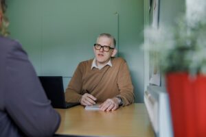 Interview met collega schrijvend en met laptop
