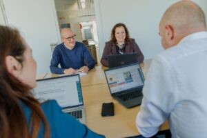 Vergadering met vier collega's achter laptops